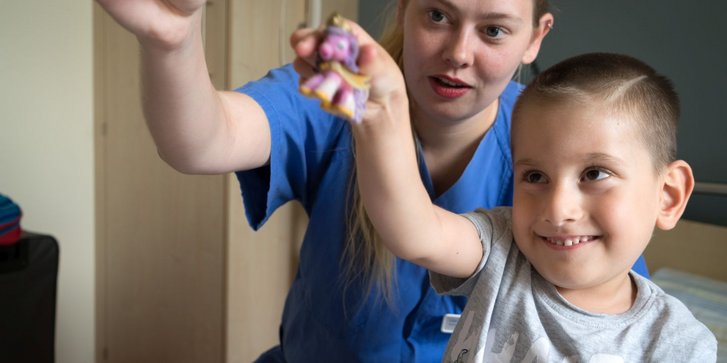 Junge spielt mit Pflegekraft